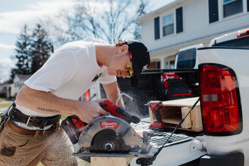 Benny Raymond of Western Michigan Handyman cutting lumber at his truck in Kalamazoo, MI