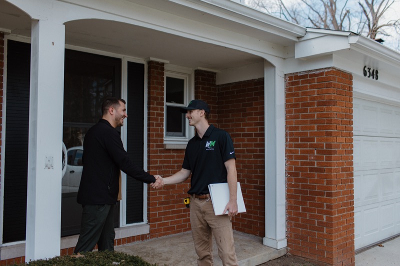 Benny Raymond, owner of Western Michigan Handyman, greeting a homeowner at a Parchment front door