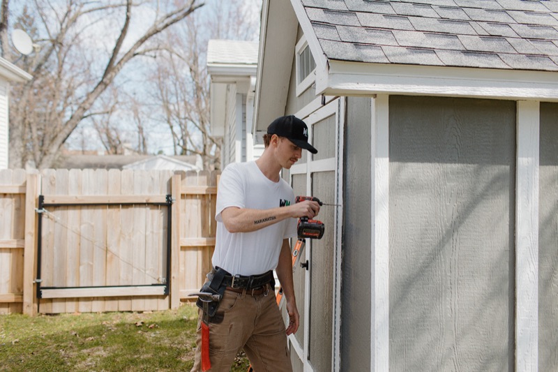 Benny fastening siding during a shed rebuild in Kalamazoo, MI