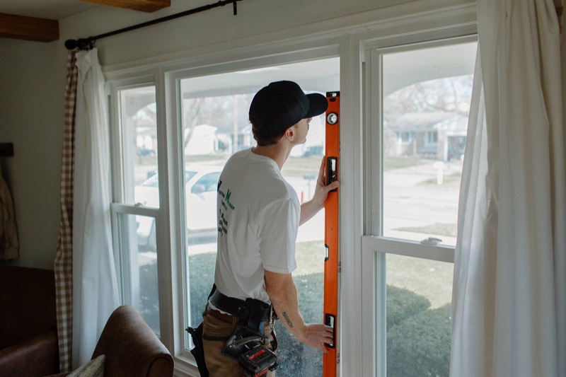 Benny leveling a replacement window during an installation in Kalamazoo, MI